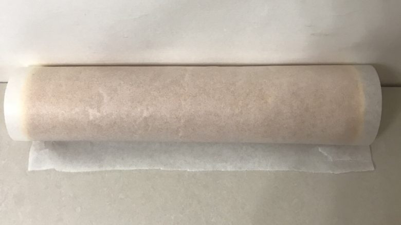 紫米核桃蛋糕卷,借助擀面仗连同油纸卷起,靠墙角定型15分钟