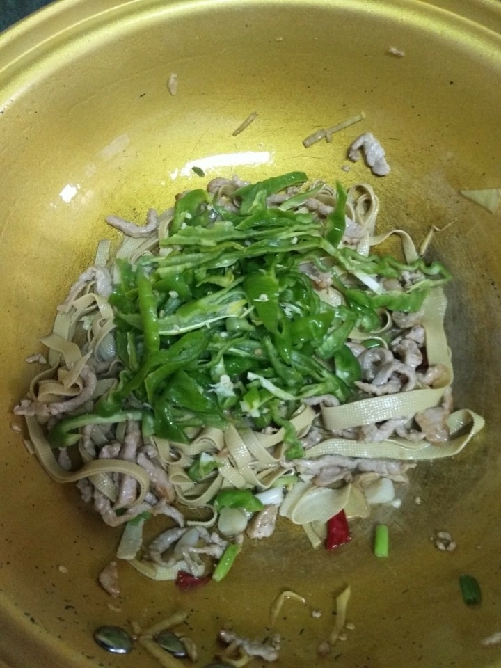 千张青椒炒肉丝,加入青椒，加适量盐，五香粉，生抽翻炒均匀