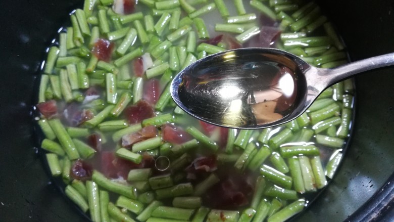 腊味豆角焖饭,倒入一勺<a style='color:red;display:inline-block;' href='/shicai/ 140122'>玉米油</a>,如果用的腊肉的味道不怎么咸,可以加一小勺盐一起煮,这样煮出来的米饭会非常的有光泽,油亮亮的,看起来会很有食欲。