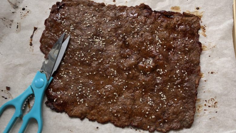 猪肉脯,取出晾凉之后,用剪刀剪去边缘烧焦的地方,修剪成条,即可食用
