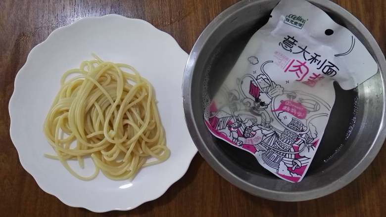 洋葱鸡蛋意面,煮好的意大利面捞到盘子里，将面酱包泡在热水里进行加热。