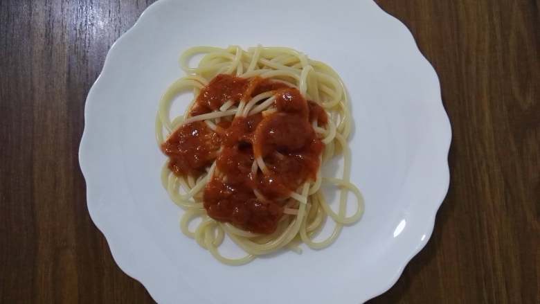 洋葱鸡蛋意面,待面酱温热后，撕开包装，将面酱挤在意大利面上。