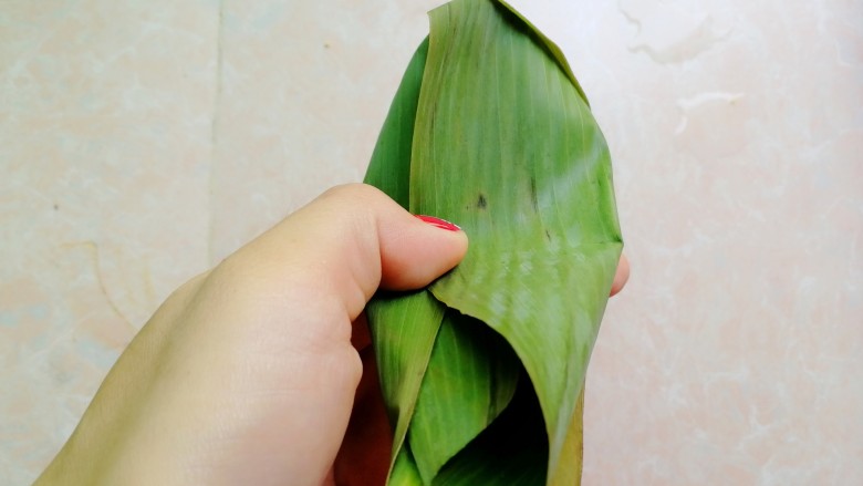杂豆蜜枣小米粽,如图这样两边的粽叶往中间压,盖住小米