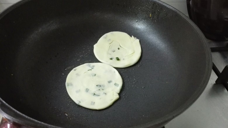 饺子皮葱油饼,锅中放少许油,放入饼,小火煎至一面金黄,