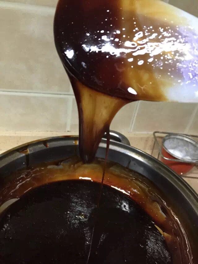 阿胶糕,泡制48小时后,将冰糖粉和阿胶倒入锅中,搅拌均匀。大火煮开,再转小火。熬煮过程中,一定要用铲子不断搅拌防止粘锅煮糊。小火一直熬制至挂旗状态(如图),这一步对于阿胶糕的制作尤为重要,关系到黄酒有没有充分的挥发。如果熬煮不到位,很容易导致做出来的阿胶糕松软;熬煮充分的阿胶糕吃起来不容易出现上火的症状。