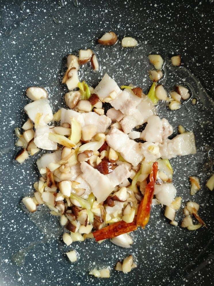 豆角焖面,放入干辣椒(不喜欢吃辣的,辣椒可以省去),倒入切好的五花肉,煸炒至五花肉变透明色。
