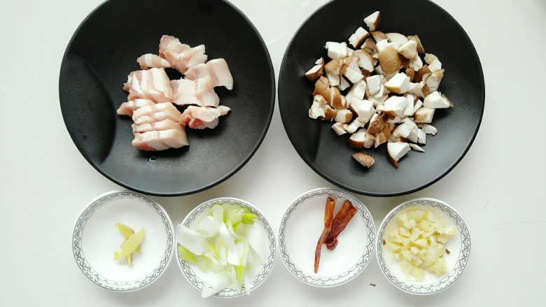 豆角焖面,把五花肉切片、香菇切丁、姜切丝、大葱切碎、蒜瓣拍碎备用。