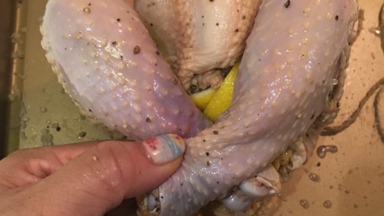 绑起来之柠檬烤鸡,翻回鸡胸那面，将两只脚交叉，正好可以堵住肚子的那个洞，20cm的麻绳将两只脚梆紧