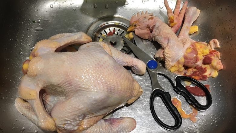 绑起来之柠檬烤鸡,用厨房剪刀剪去脖子以上的头颈部、鸡爪、多余的脂肪，除去体腔上的淤血，清洗干净