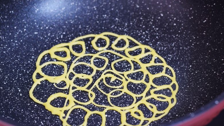 鸡蛋网饼卷,锅中烧热，然后在锅里挤出一个个圆圈，小火煎至凝固变色