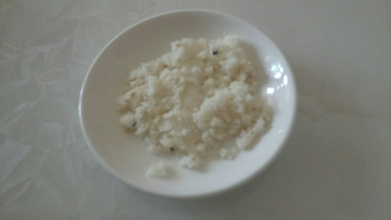 榴莲米糕塔,取一个米糕,用刀横着切成薄片,除了最上面的一片,其余的用手捏碎,盘子上垫一层米糕碎。