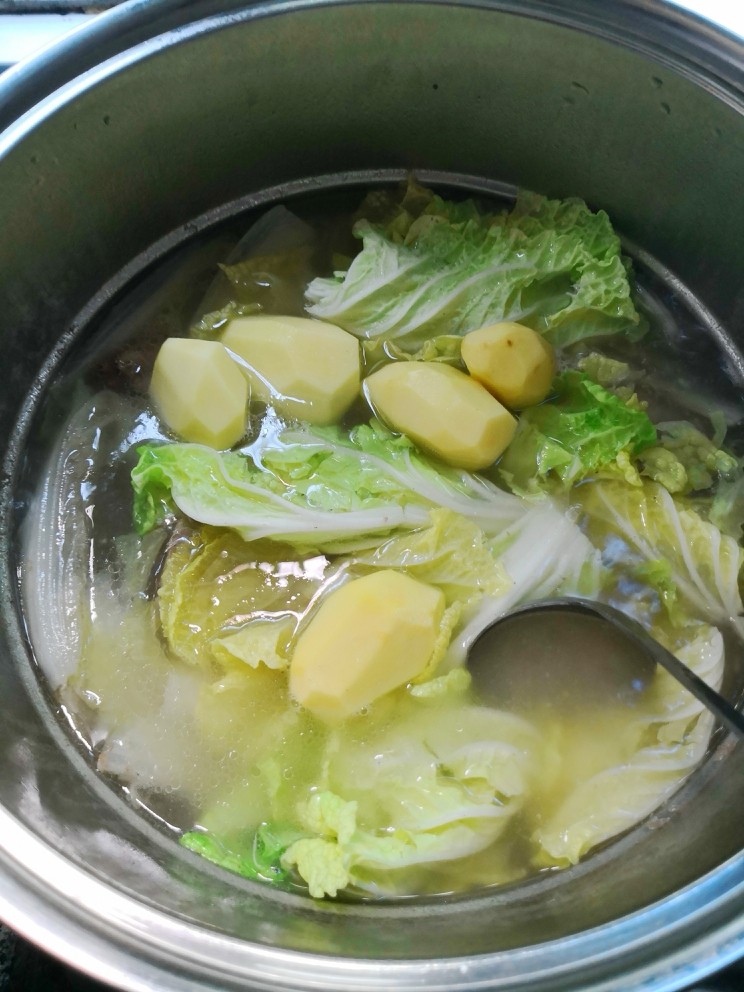 土豆大白菜炖猪大骨,一个半小时左右后再放入大白菜叶子与整个土豆炖至土豆烂醉,这时大白菜也都茸了