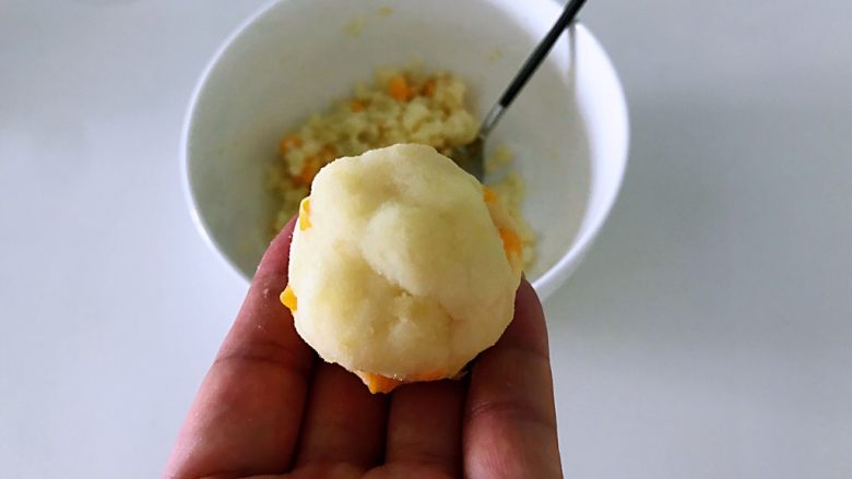 玉米粒土豆泥，惊艳味蕾的做法,土豆去皮趁热压成泥，加入玉米粒和盐，拌匀，捏成球。