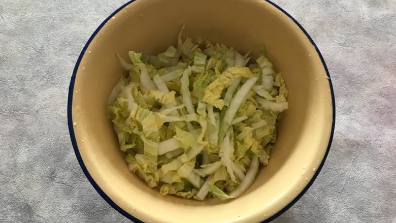 虾干拌娃娃菜,然后双手捧住盆子,上下颠10几20下,让盐和娃娃菜充分混合,然后静置15分钟