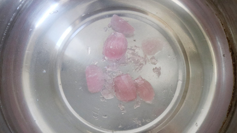 浪漫情怀樱花冻,小锅中倒入清水烧开后加入粉色糖果,煮到糖果融化,再倒入一个碗中,加入一勺子<a style='color:red;display:inline-block;' href='/shicai/ 865'>蜂蜜</a>,将其溶解开。