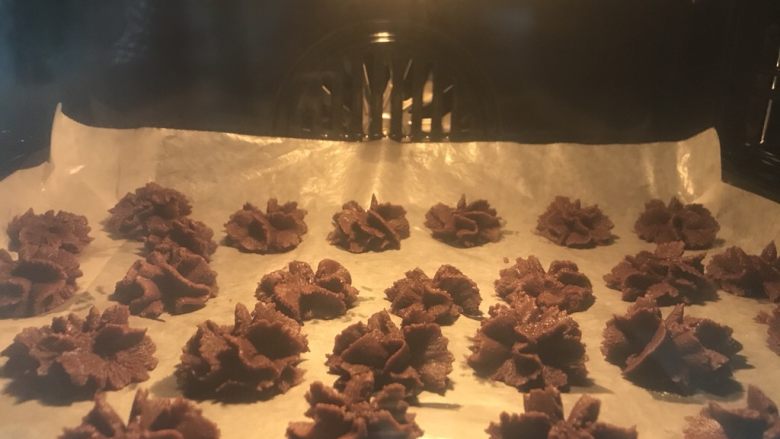 香酥曲奇饼干,这是一个大号六齿裱花嘴裱的可可曲奇,裱这种花还挺好看。烤箱要提前预热165度大概20分钟就差不多了,但是烤的过程中要随时看一下烤箱内状态,感觉颜色可以了就行了。