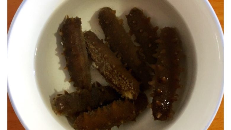 野生淡干海参泡发全过程,把海参捞起来,装在干净无油容器里,加入纯净水,也可以加几个冰块