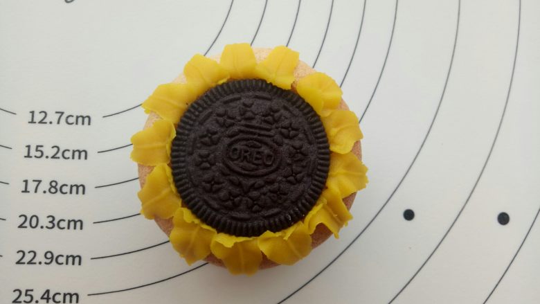 向日葵纸杯蛋糕 ,贴着奥利奥的边缘挤一圈向日葵花瓣,这是第一层。