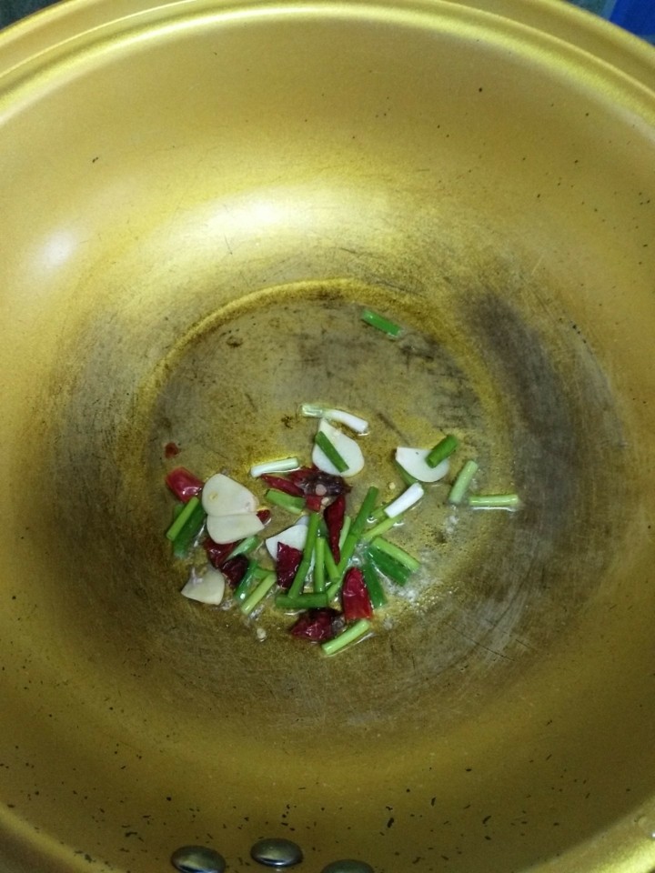 孜然青椒炒鱼豆腐,锅内放入适量油,放入蒜片,辣椒,葱段炒香