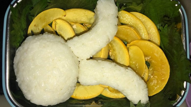 珍妮珍馐儿童香肠便当,把紫苏铺在饭盒底部和四周,南瓜排放在紫苏上,然后用手捏握出小兔子的头和耳朵