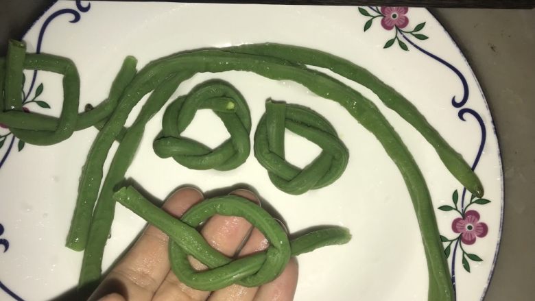豇豆花环肉丸,捞起晾凉后如图打结,在绕成花环状