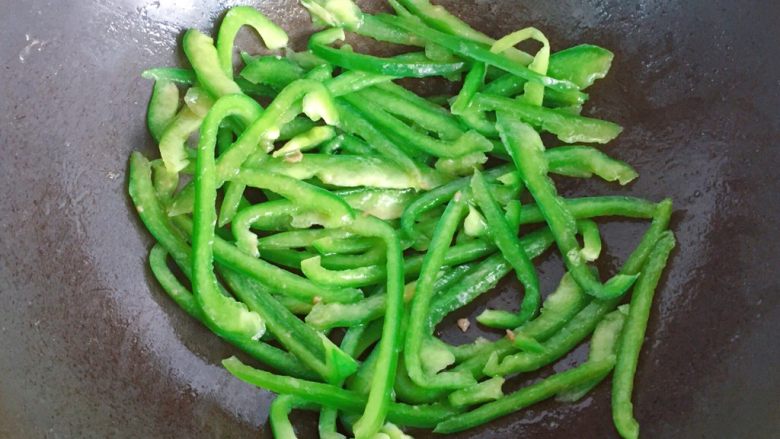 青椒炒牛肉丝,继续加少许油,倒入青椒丝翻炒几下至稍稍变软;