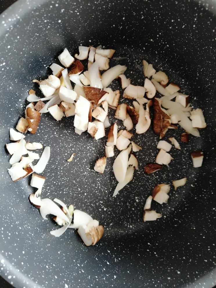 土豆腊肉香菇饭,待油温7至8成热时,放入葱白爆香,继续放入香菇爆香。