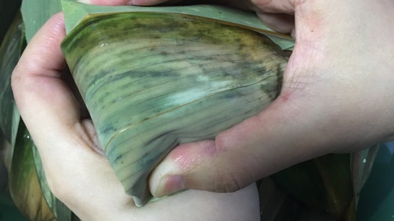 咸蛋黄肉粽,两侧边往下压包住,用绳子缠紧