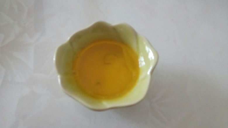蔓越莓椰蓉酥,将玉米油倒入<a style='color:red;display:inline-block;' href='/shicai/ 15'>蛋黄</a>中,搅拌均匀。