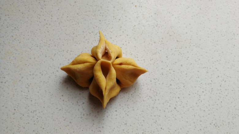 黄金花式豆沙馒头,捏好后再次把两边向外对折捏紧,然后整理下让它更有型漂亮。