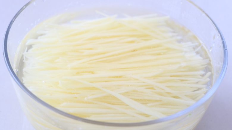 土豆丝炒胡萝卜,放入清水里,洗去淀粉;