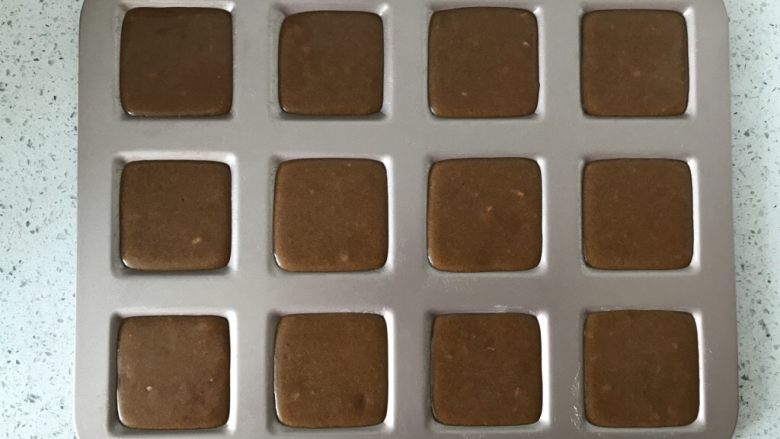 咖啡大杏仁费南雪,静置好的面糊挤入模具中约8分满,轻震几下盘,震出气泡。
