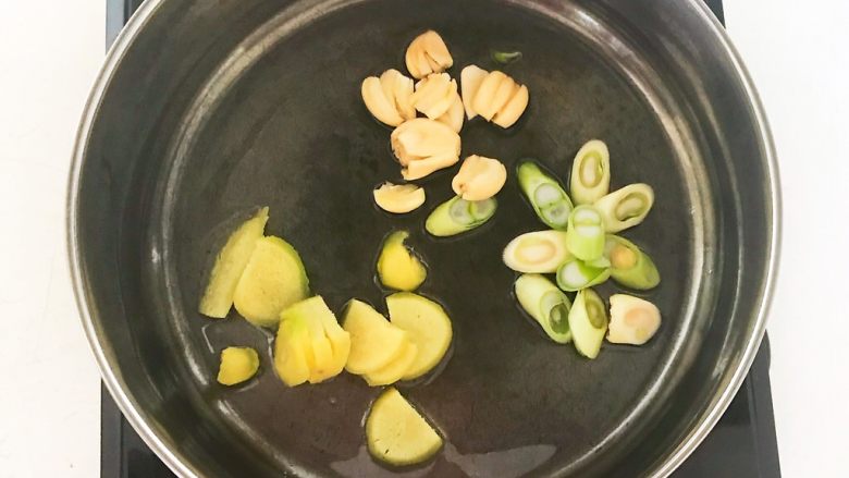 家常美味酸菜鱼,炒锅烧热后加入1勺大豆,油温6分热的时候加入切好的葱姜蒜,炒出香味