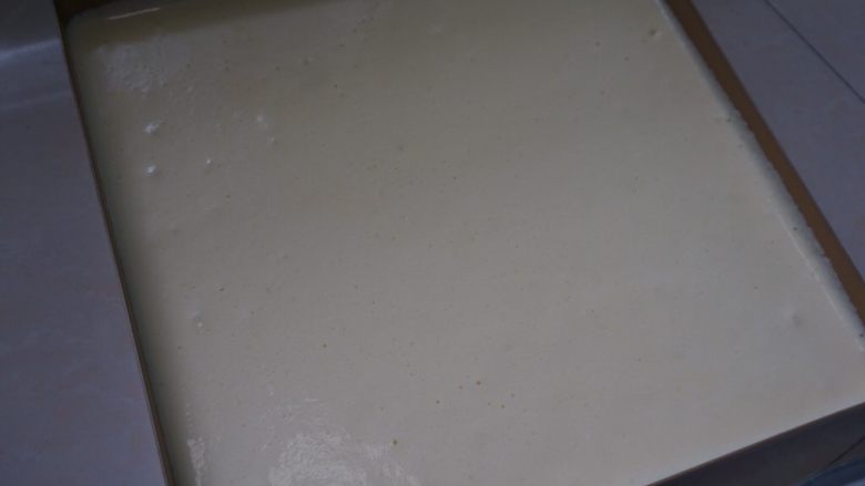 芒果杯子蛋糕,然后将蛋糕糊倒入铺油布或油纸的烤盘中,震泡两次