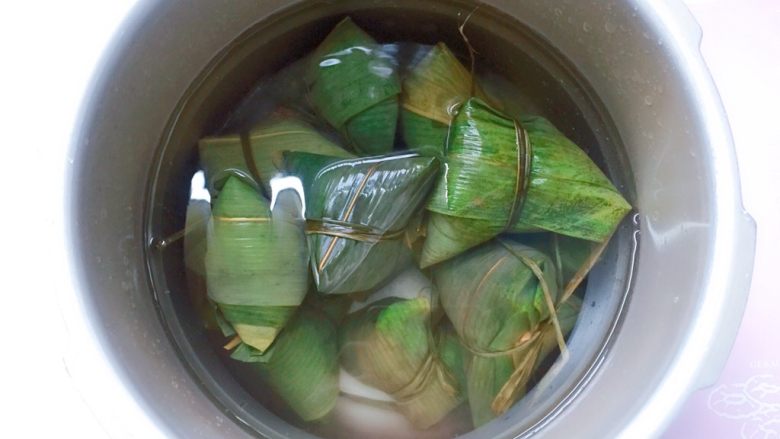 花生蜜枣粽,将包好的粽子放入高压锅中,加入足量的清水(水量一定要没过粽子),大火煮开转中小火煮一个小时,煮好以后在锅里再焖两个小时后捞出,口感更黏糯。