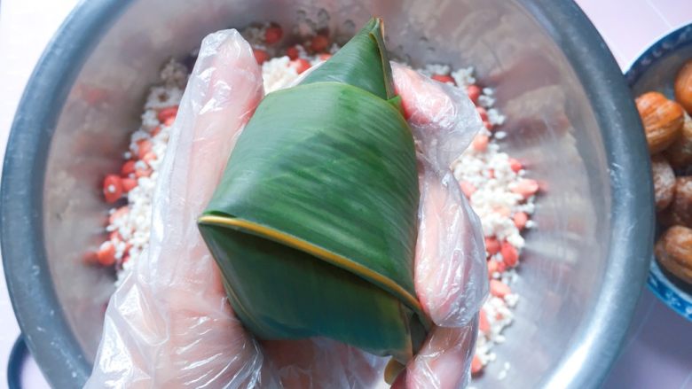 花生蜜枣粽,顺着边边将粽叶折好;