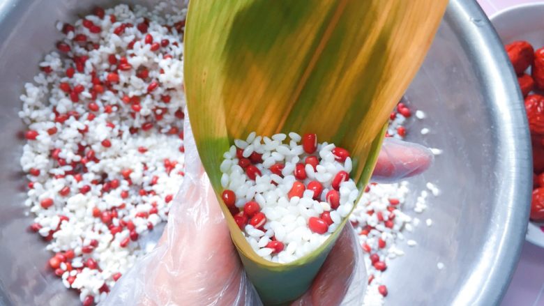 红豆红枣牛角粽,再加入2/3的红豆、糯米,压实(九分满即可)。