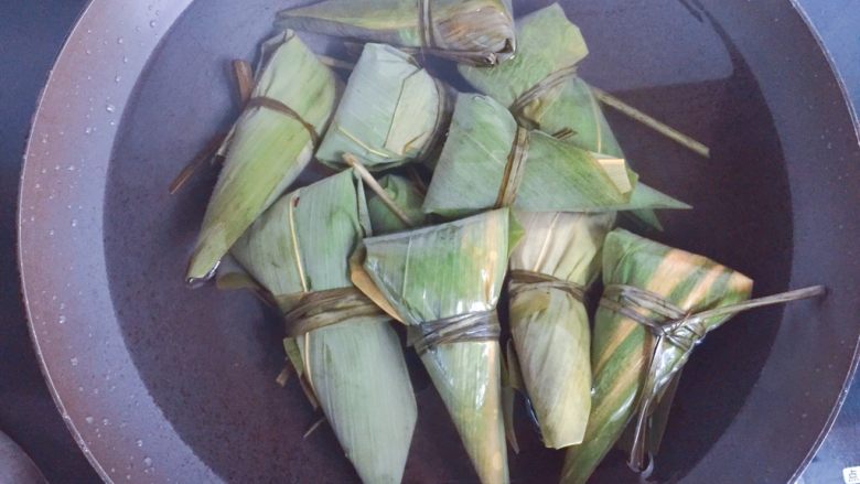红豆红枣牛角粽,全部包好后放入煮锅,加入足量的清水(水一定要没过粽子),大火煮开转中小火煮一个小时,煮好以后在锅里再焖两个小时后捞出,口感更黏糯。