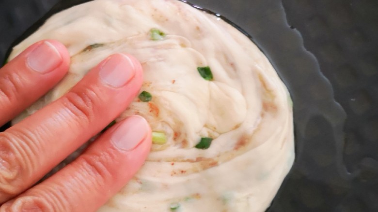 香葱千层饼,电饼铛预热后放入少许植物油(熟),将图二十一中的面团放入电饼铛中,并用手按压成小面饼