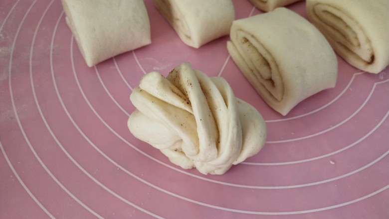 五香花卷,左手和右手合拿一头,两手朝反方向拧,两头交接,头朝下,依次全部做好