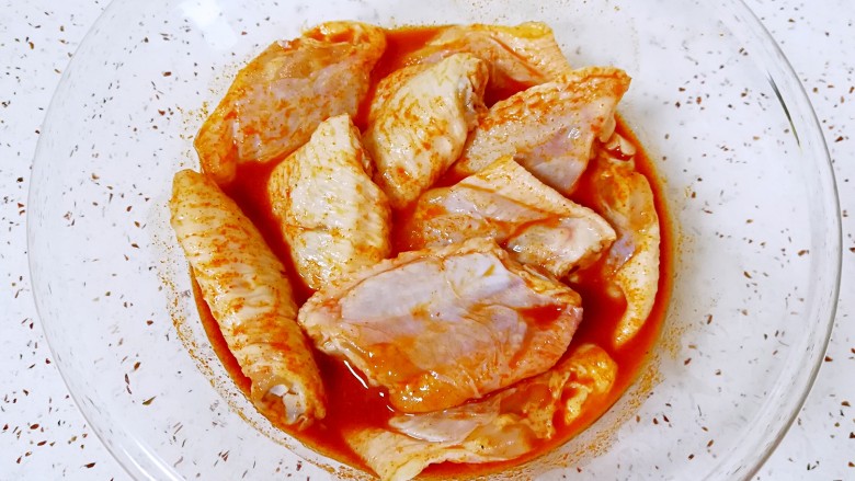 土豆烤鸡翅,放入鸡中翅,带上一次性手套抓捏均匀,盖上保鲜膜腌制4个小时以上,中间再抓捏几次。