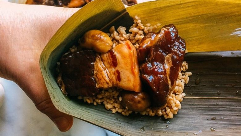 端午肉粽,先放一勺糯米,然后放肉跟板栗。