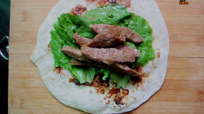 嫩牛五方,铺2片<a style='color:red;display:inline-block;' href='/shicai/ 121'>生菜</a>叶,放入适量牛肉
