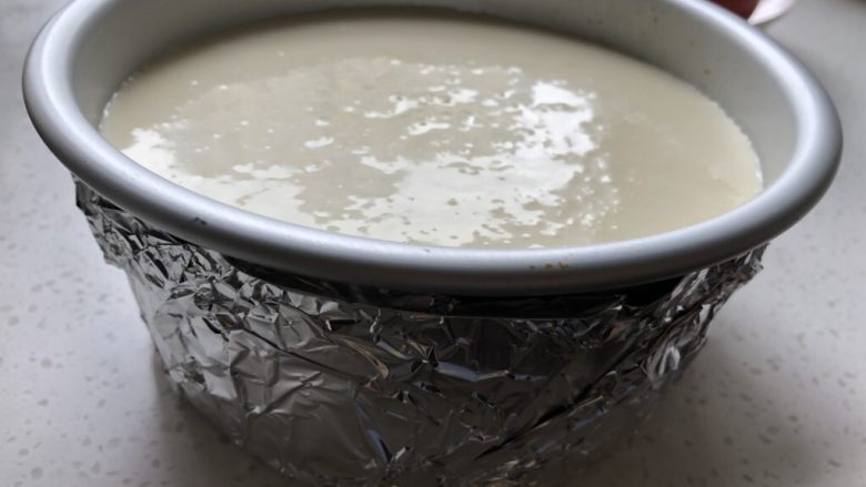 重乳酪蛋糕(原味),倒入我们事先准备好的饼底的模具中,如果是活底模具,要包好锡纸避免模具内进水