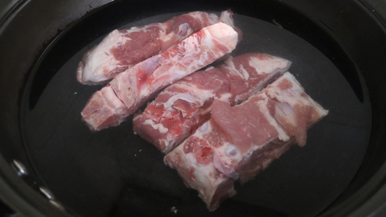 排骨豆角焖面,排骨凉水下锅,大火烧开后再煮5分钟,用勺子将水面上的浮沫撇干净,将焯好的排骨捞出,控净水分。