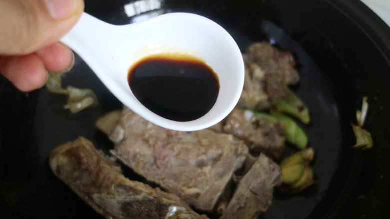 排骨豆角焖面,淋入调好的生抽和蚝油,翻炒均匀,放入豆角,和排骨一起翻炒均匀。