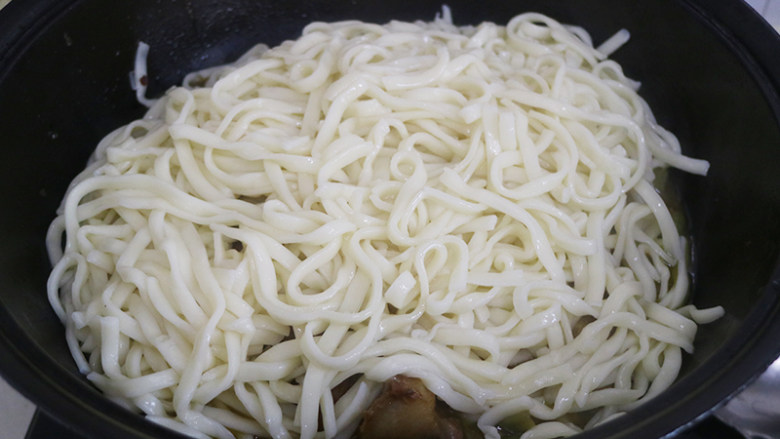 排骨豆角焖面,把面条均匀的铺在豆角上中小火盖上锅盖焖20分钟左右,汤汁收干后,把面条和豆角排骨拌匀。
