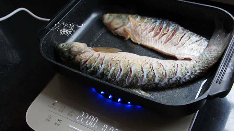 香辣烤鱼,煮蔬菜的时候来煎鱼,准备一个韩式烤盘,直接在烤盘里加入油,烧热后摆入草鱼来煎。