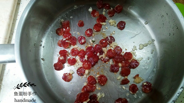 腊肠菜心粒,把锅烧热,食用油倒入锅里。把腊肠倒进去翻炒。油不用多,腊肉会出油,翻炒几下后加入少量的盐。然后把蒜粒倒入并翻炒均匀。