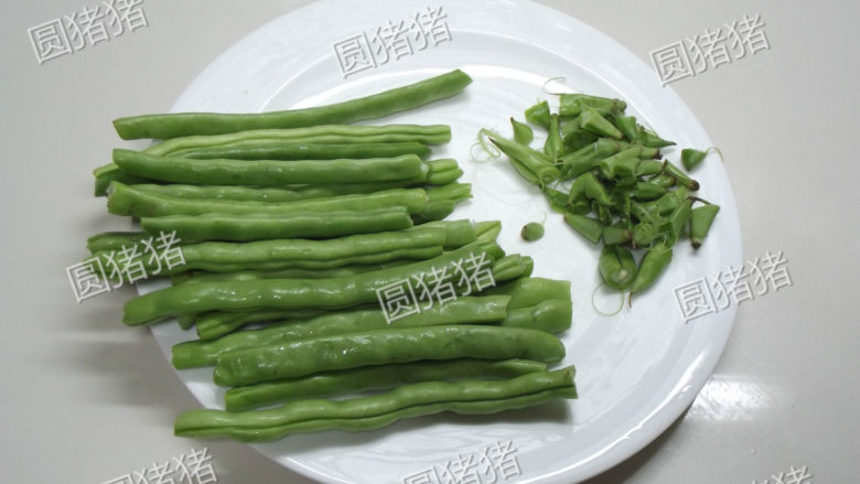 榄菜肉末炒豆角,用手将豆子头尾两头的尖连着筋撕下来。